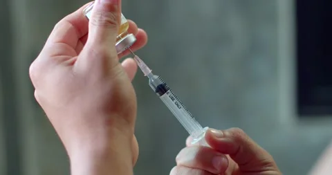 Using syringe suck out of bottle by turning the medicine bottle upside down. Stock Footage 254198204