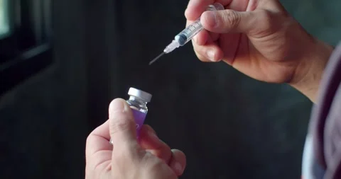 Using syringe suck out of bottle by turning the medicine bottle upside down and  Stock Footage 254505937