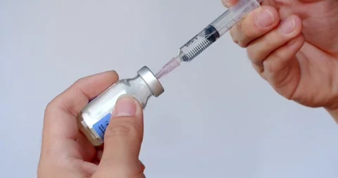 Using syringe suck out of bottle by turning the medicine bottle upside down. Stock Footage 277842836