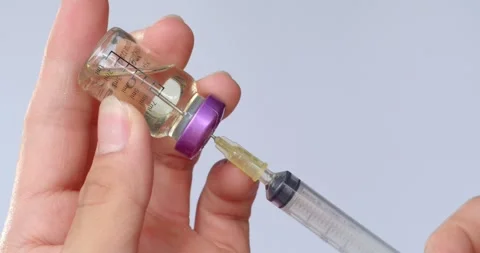 Using syringe suck out of bottle by turning the medicine bottle upside down. Stock Footage 277842893