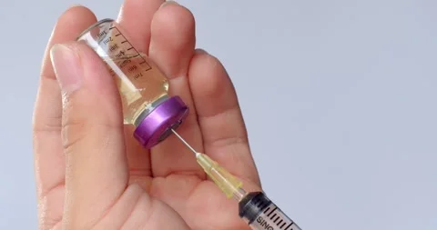 Using syringe suck out of  purple bottle by turning the medicine bottle. Stock Footage 263575116