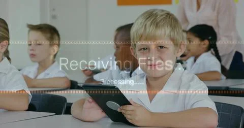 Using tablet front boy doing digital task in class in white collared shirt Foto stock