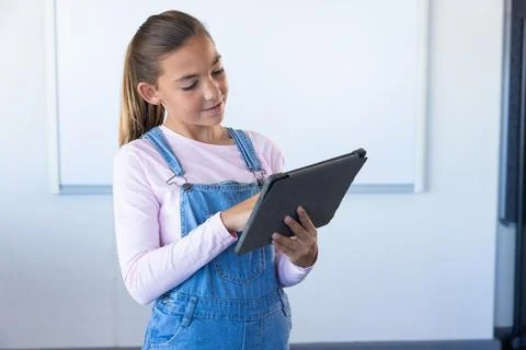 Using tablet, girl in school classroom focusing on digital learning 写真素材