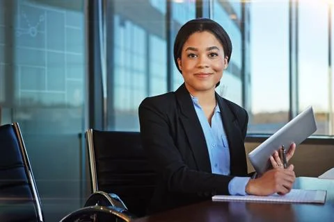 Using a tablet helps to keep clutter at bay. a businesswoman taking notes while Stock Photos