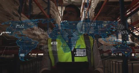 Using tablet hi-vis vest clad worker viewing digital map overlay in warehouse Stock Photos