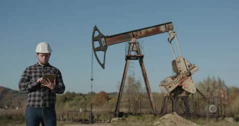 Using Tablet in Industrial Environment. Engineer in hardhat is using a tablet Stock Footage 195248696