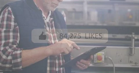 Using tablet, man in industrial setting with social media likes image overlay 스톡 사진