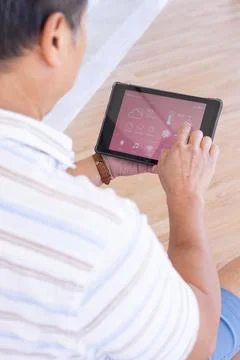 Using tablet, senior man controlling smart home devices with touchscreen Stock Photos