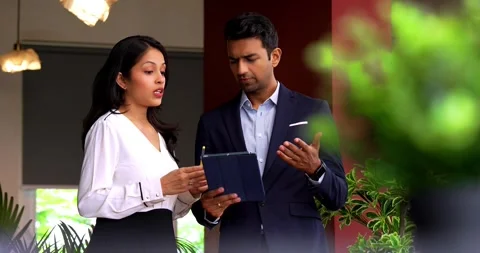 Using tablet while chasing deadline, Indian business colleagues discuss project Video stock 342593690