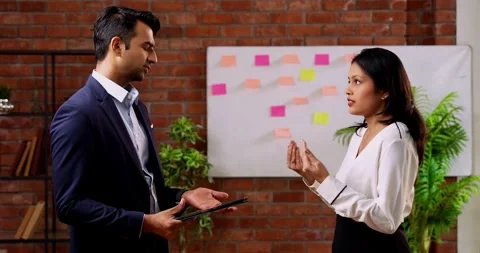 Using tablet while chasing deadline, Indian business colleagues discuss project Video stock 342593825