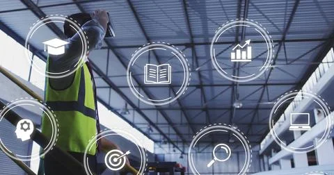 Using tablet worker wearing safety vest by railing monitoring data icons in Stock Photos