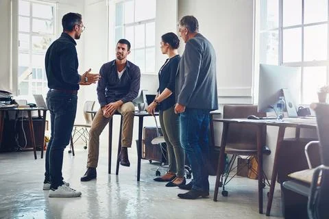 Using team-based approaches to solving problems. a group of designers having a Stock Photos