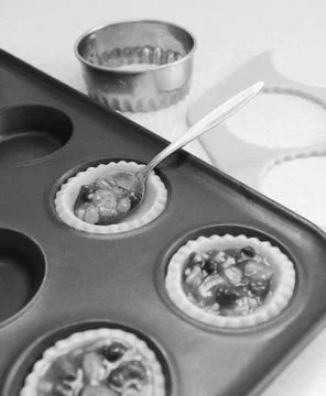Using teaspoon to fill pastry cases with mincemeat Stock Photos