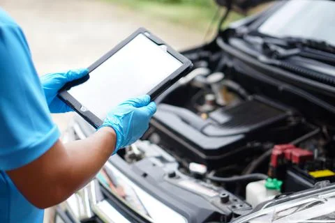 Using technology to manage car engine. Car service and maintenance. Stock Photos