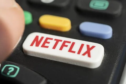 Using a television remote with a dedicated Netflix logo on button. TV remote  Stock Photos