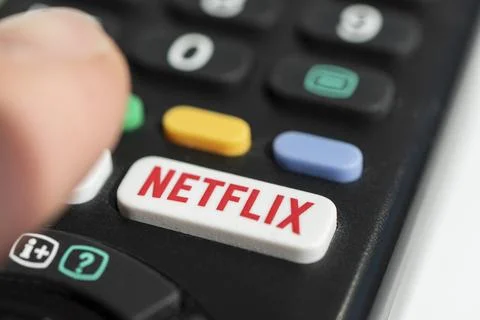 Using a television remote with a dedicated Netflix logo on the button. TV r.. Stock Photos