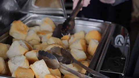 Using tongs to get biscuit from buffet Stock Footage 115732077