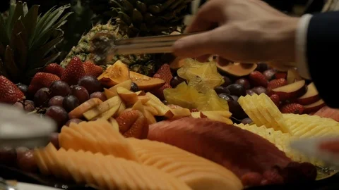 Using tongs to pick up fruit from fruit tray 動画素材 103549778