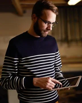 Using touchscreen technology. a hipster using a touchscreen device. Stock Photos