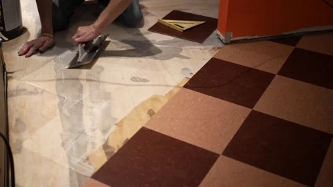 Using a trowel to spread adhesive glue on a floor for installation of vinyl Vidéo 278989970