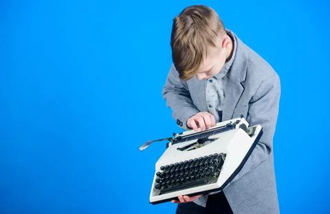 Using a typing machine. Small kid typewriting on old typewriter. Smart schoolboy Stock Photos