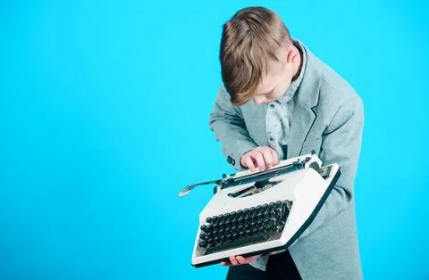 Using a typing machine. Small kid typewriting on old typewriter. Smart schoolboy Stock Photos