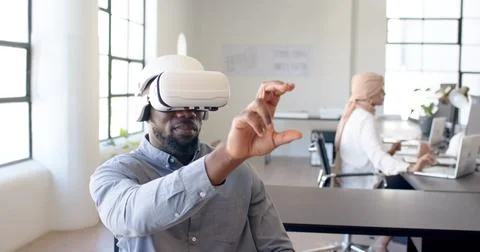 Using VR headset, man interacting with virtual interface in modern office Photos
