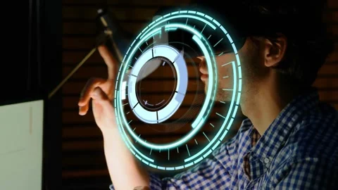 Using VR headset, man wearing checked shirt manipulating holographic rings at Stock Footage 331571132