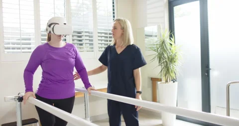Using VR headset, woman in prosthetic leg walking with therapist on parallel Video stock 299229116