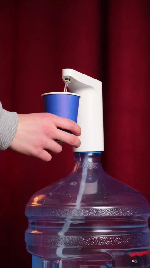 Using water pump to fill paper cup Stock Footage 306779866