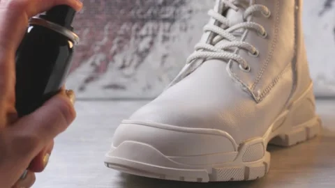 Using waterproof spray for white color winter shoe Stock Footage 146291463