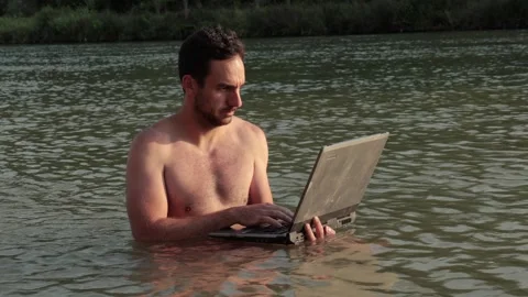 Using work laptop on the beach, in the water Stock Footage 306656261