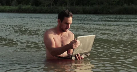 Using work laptop on the beach in the water Stock Footage 311172480