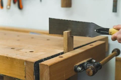 Using workbench vise for cutting wood with a handsaw Stock Photos