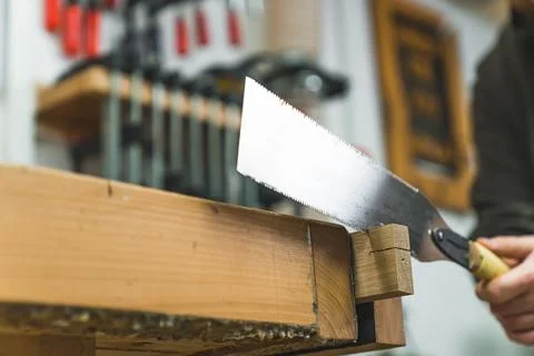 Using workbench vise for cutting wood with a handsaw Stock Photos