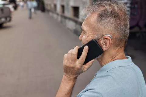 Using your hearing aids with a smartphone . Senior man with hearing aid beh.. Fotos Stock
