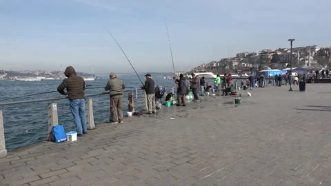 Uskudar seafront and fishermen with rods one winter day Stock Footage 312752353