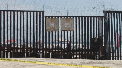 US/Mexico Beach Border: Border wall barbed wire separates San Diego Tijuana Stock Footage 114785208