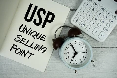 USP Unique Selling Point text on paper notebook page with alarm clock and c.. Stock Photos