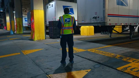 USPS Postal Worker Standing Near Mail Trucks at Night Stock Footage 335415892