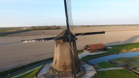 Utch windmill with open field in the back shot by drone moving upwards with some 動画素材 128385203