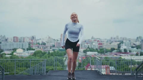 Utdoor ExercisA Joyful Runner Ascending Urban Heights, Embracing Fitness and Stock Footage 313854831