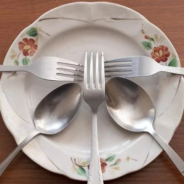 Utensils arranged on a patterned porcelain Stock Photos