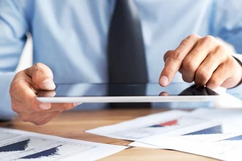 Utilising touchscreen functionality. Cropped view of a mans hands using a Stock Photos