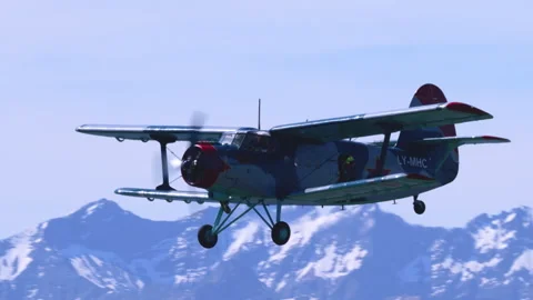 Utility Aeroplane Antonov AN-2 Level Profile Fly-By Alpine Range Tracking Shot Stock Footage 332324569