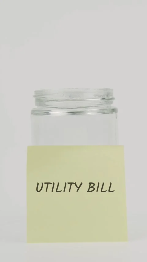 Utility bill text or word on yellow sticky note attached to glass jar Stock Footage 311801659