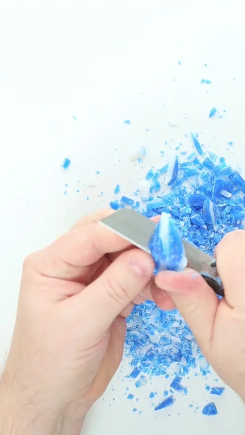 Utility blade scraping blue soap flakes for crunchy ASMR Video stock 336265559
