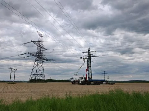 Utility crane installing equipment beneath high voltage transmission lines Stock Photos