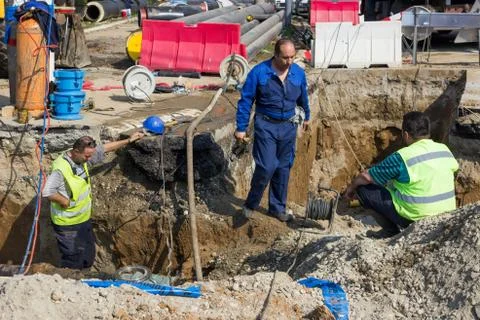 Utility crew fixing broken water main Stock Photos