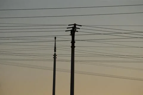 Utility infrastructure captured through layered wires against dusk sky Stock Photos